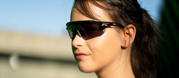 Runner on course during a road marathon, wearing Re. sunglasses in morning light