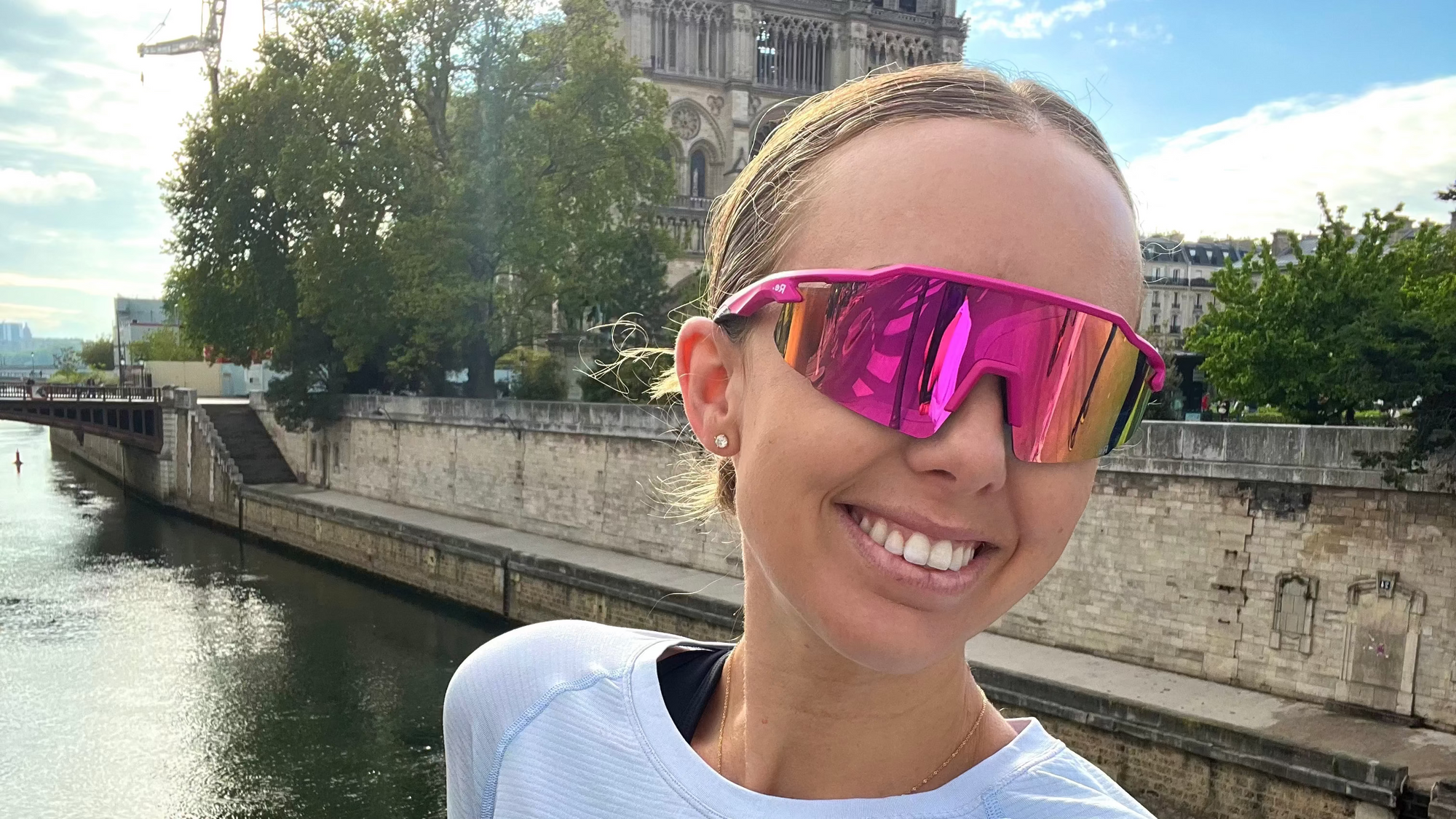 Person wearing pink sunglasses with a cityscape in the background